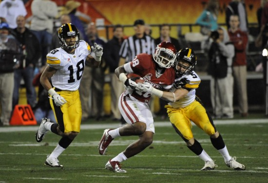 Dec 30, 2011; Tempe, AZ, USA; Oklahoma Sooners wide receiver Kameel Jackson (18) catches a pass while being pursued by Iowa Hawkeyes defensive back Micah Hyde (18) during the first half of the 2011 Insight Bowl at the Sun Devil Stadium. Mandatory Credit: Richard Mackson-USA TODAY Sports