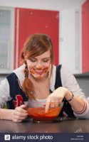 young-woman-eating-tomato-sauce-in-kitchen-munich-bavaria-germany-XCFJ9E.jpg