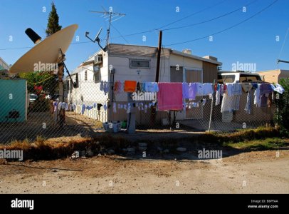 trailer-park-with-large-satellite-dish-drying-laundry-on-chainlink-B6PFAA-3298950892.jpg