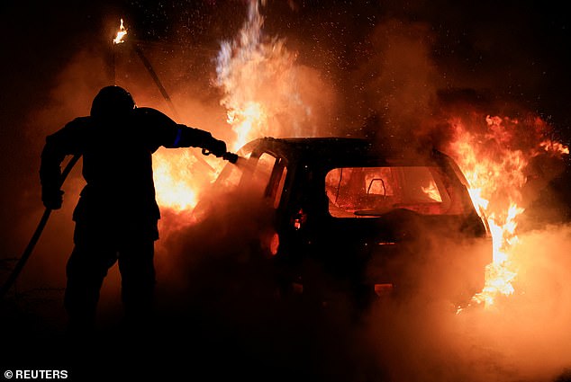 72783781-12257991-A_French_firefighter_works_to_extinguish_a_burning_car_during_th-a-2_1688407177053.jpg