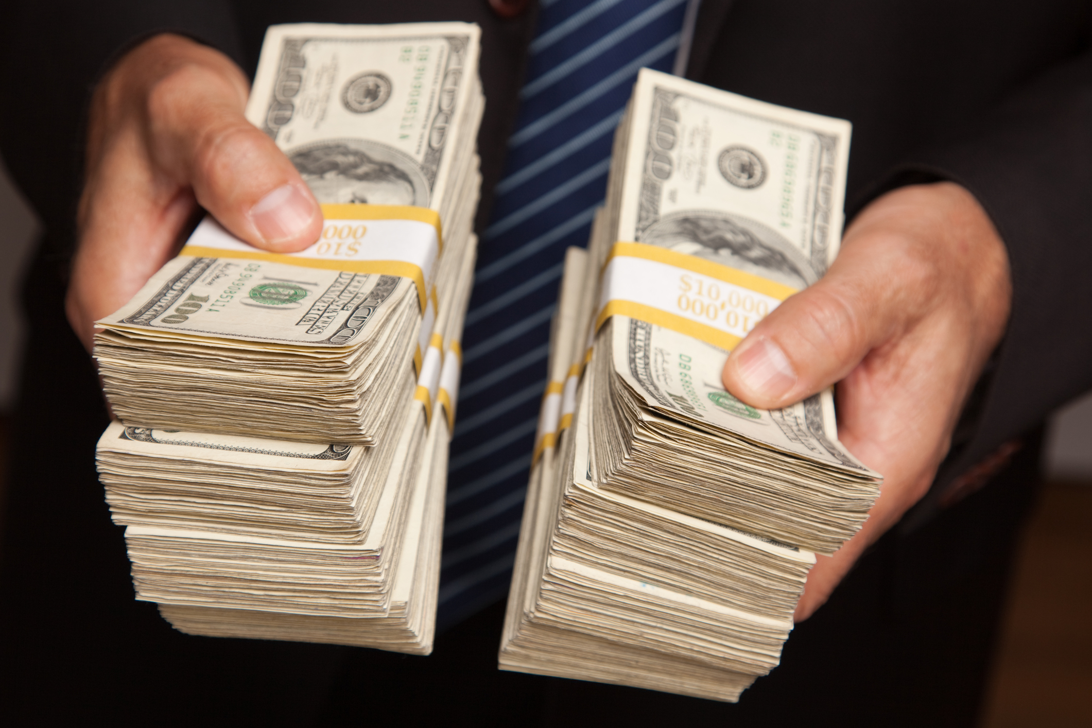 businessman-with-stacks-of-money-cash-getty.jpg