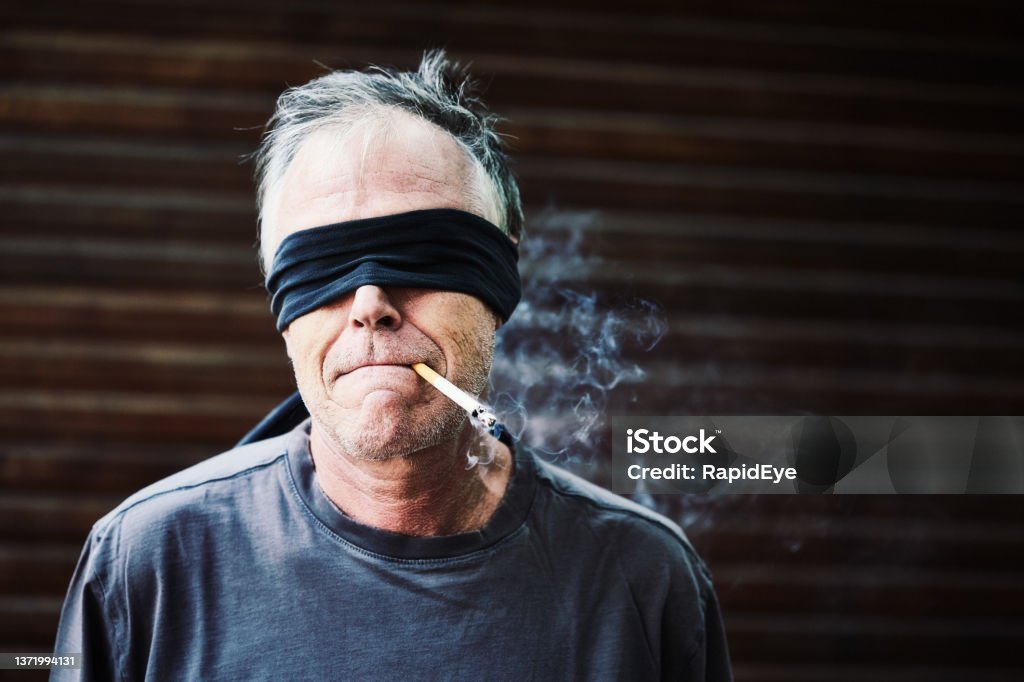 blindfolded-man-awaits-the-firing-squad-smoking-his-last-cigarette.jpg